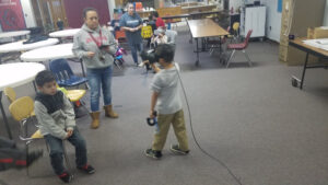 Older students teaching younger ones VR techniques and experiences.